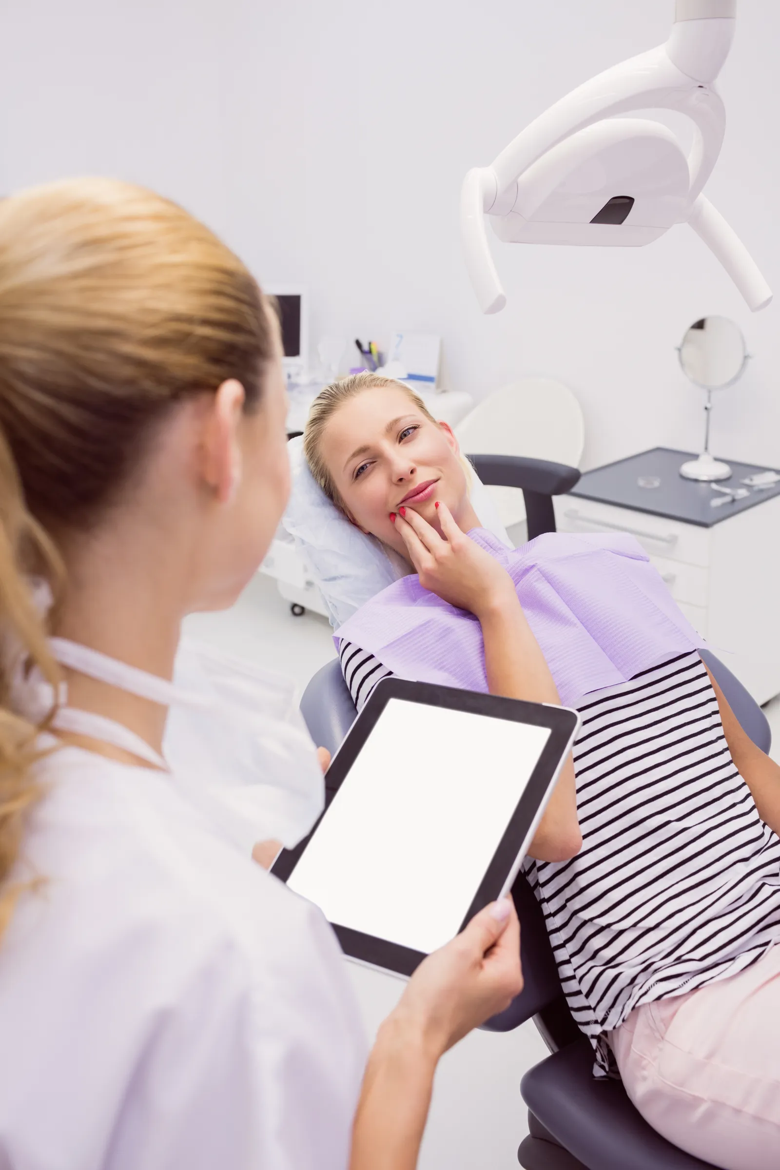 Patient holding her jaw with toothache at a dental clinic