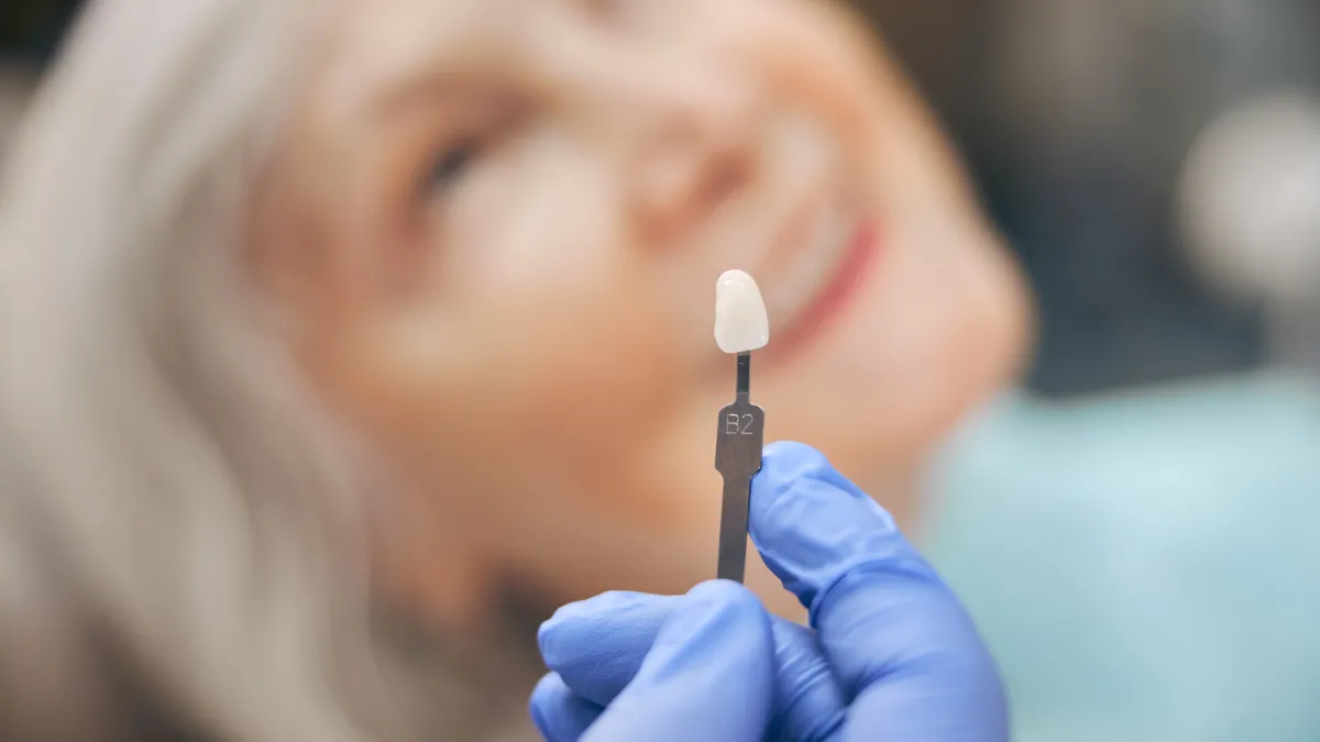 Porcelain dental crown held by a gloved hand at Plumas Family Dentistry, Yuba City, CA 95991
