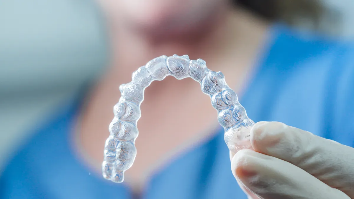 Clear Invisalign aligner held by a dentist at Plumas Family Dentistry in Yuba City, CA 95991